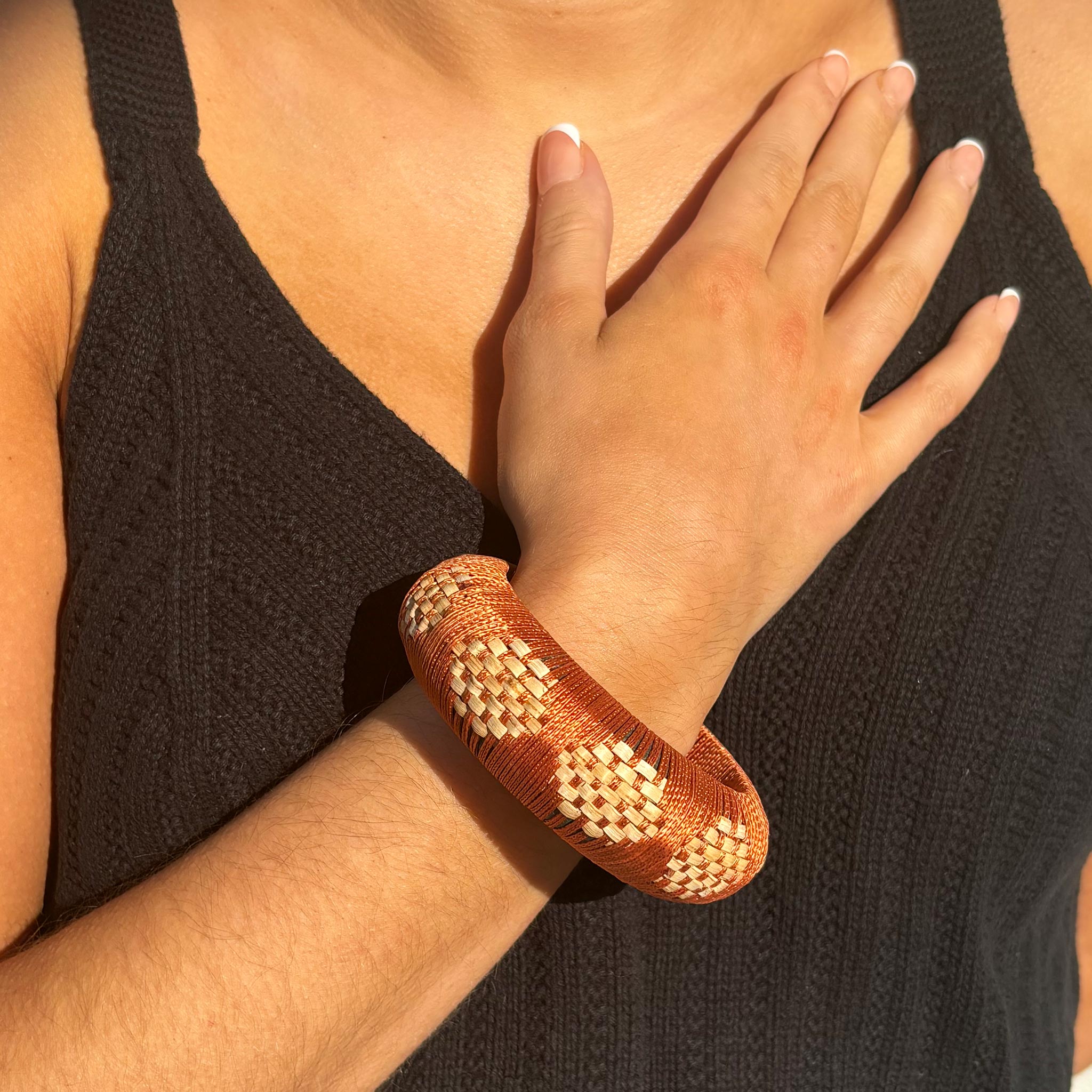 Pulsera tejida a mano Lalika: algodón naranja vibrante con contraste de ratán natural